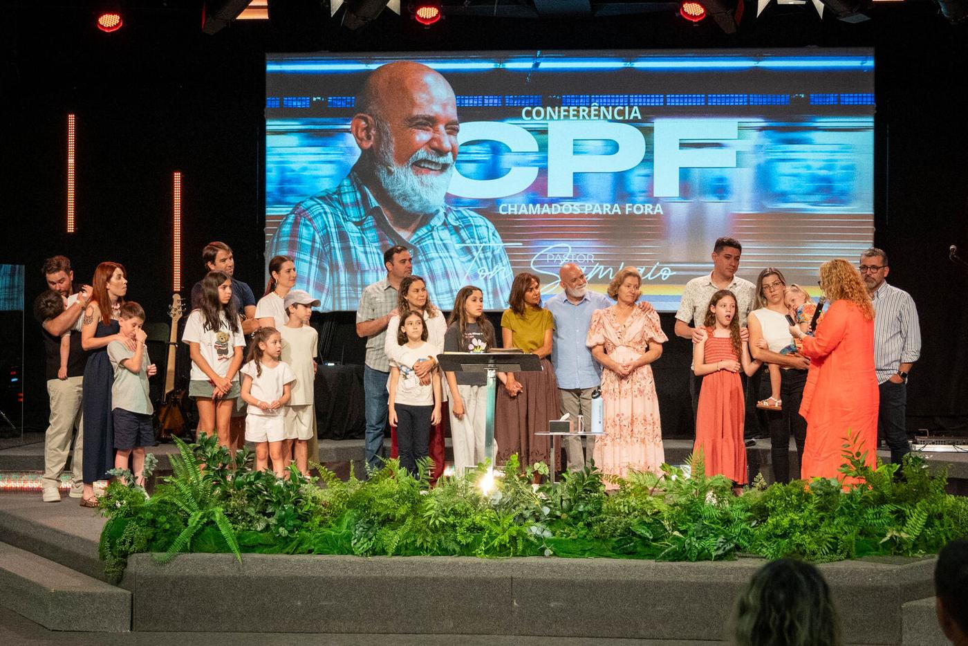 Equipe e participantes no palco da conferência Chamados Para Fora