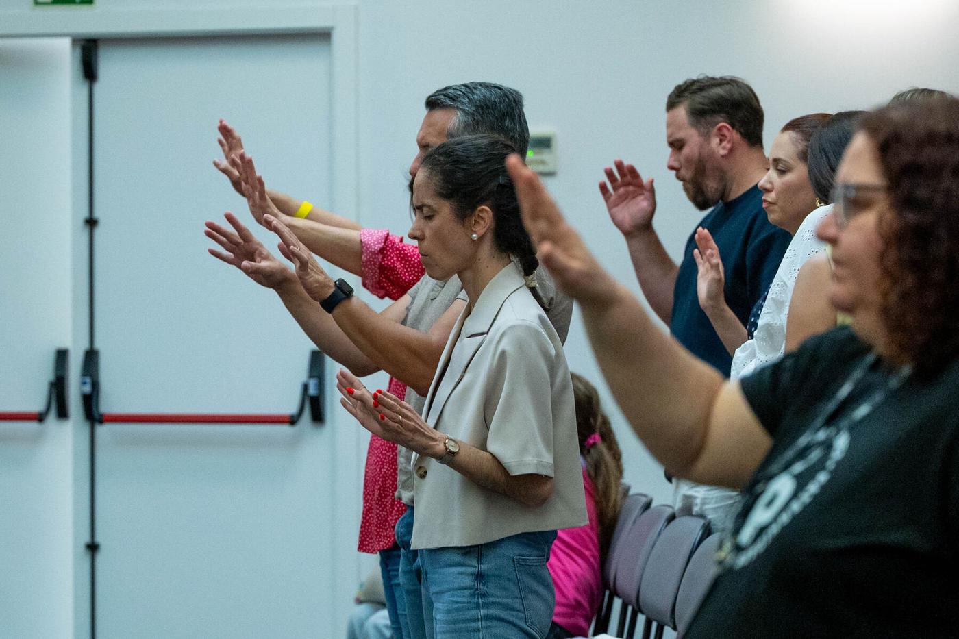 Pastores e participantes orando no palco