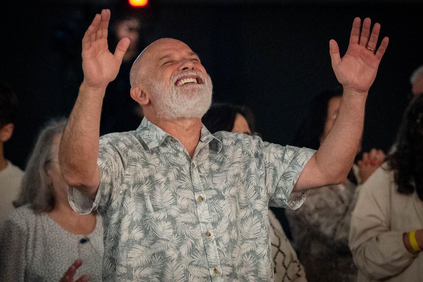 Pr Ton Sampaio sorrindo com as mãos levantadas na conferência