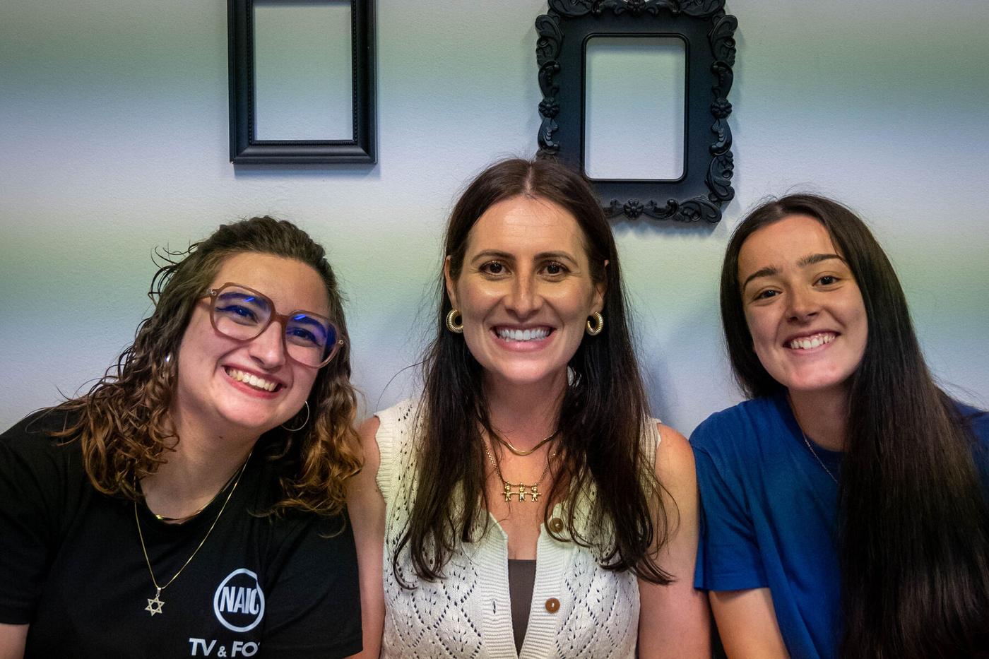 Três alunas sorrindo juntas